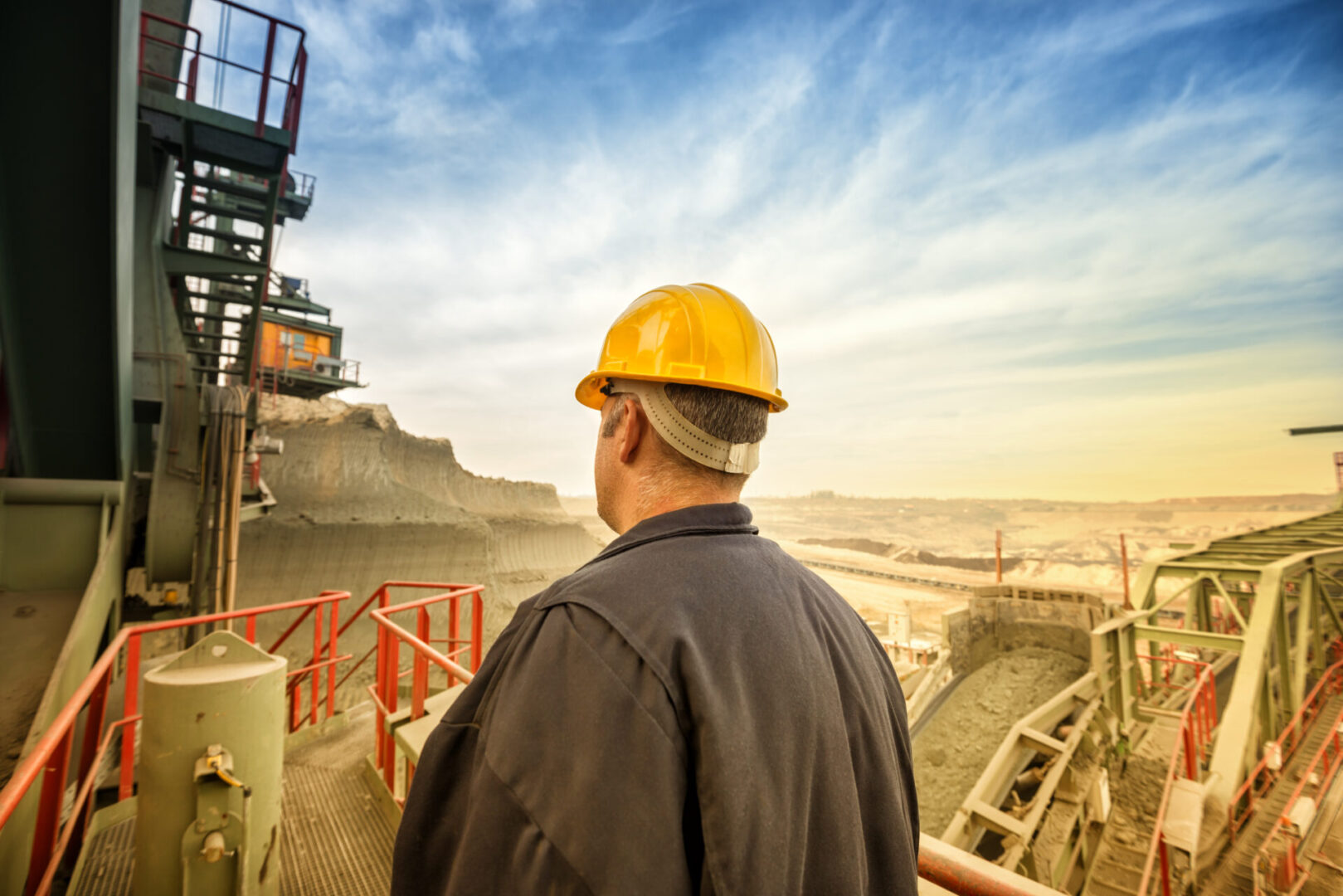 Worker overlooking open-pit mine.